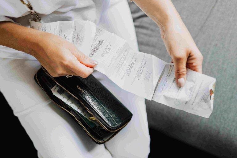 A grocery receipt and calculator on a kitchen counter, used to track a weekly food budget